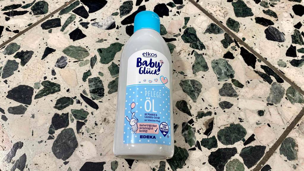 Babyöl getestet: Auf einem Fließenboden liegt eine Flasche Öl