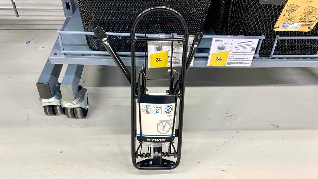 Fahrrad-Gepäckträger im Test: ein schwarzer Fahrrad-Gepäckträger an einem Regal angelehnt.