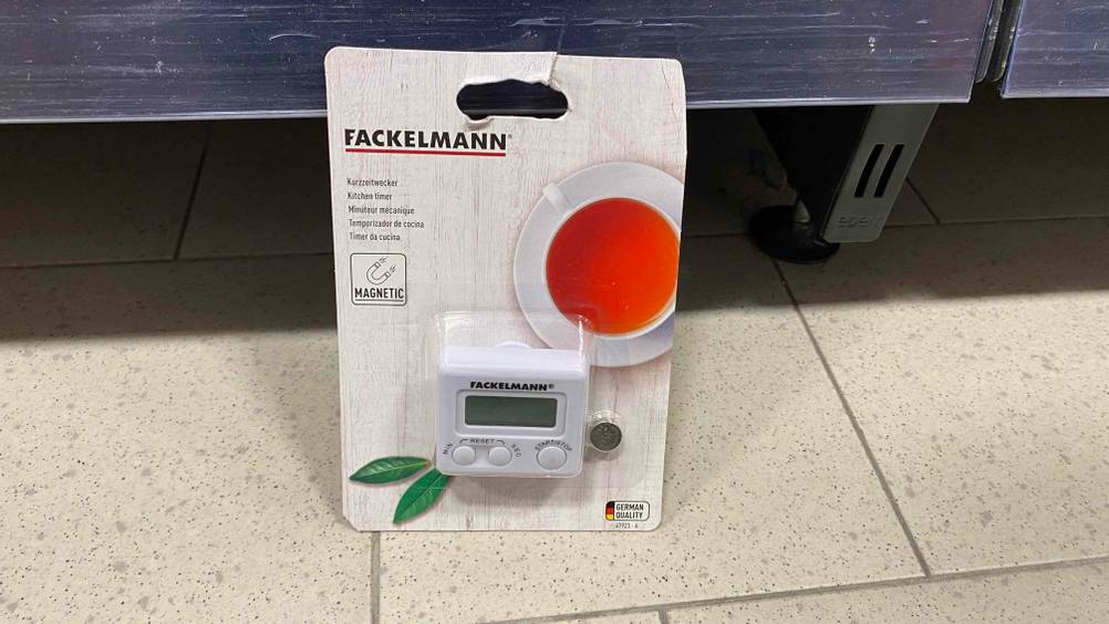 Kurzzeitwecker getestet: Ein verpacktes Gerät lehnt an einem Regal.