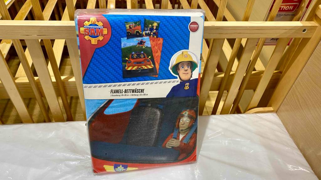 Flanell-Bettwäsche getestet: In einem Kinderholzbett steht eine verpackte Bettwäsche.
