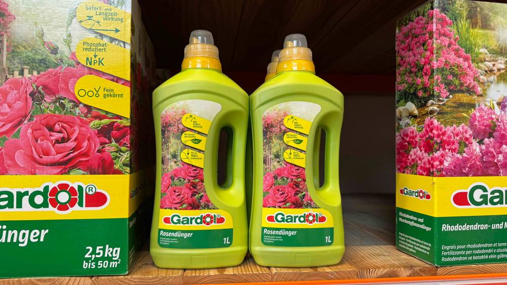 Zwei getestete flüssige Rosendünger stehen in einem Regal neben anderen Rosendüngern.