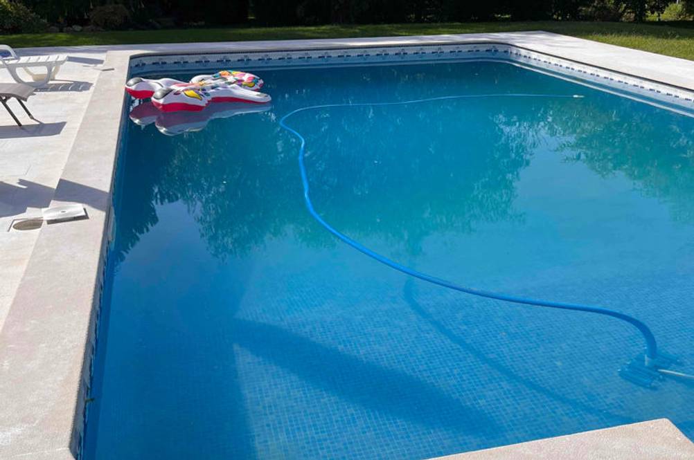 Ein getesteter Gartenpool mit einem Schwimmtier und einem Schlauch.