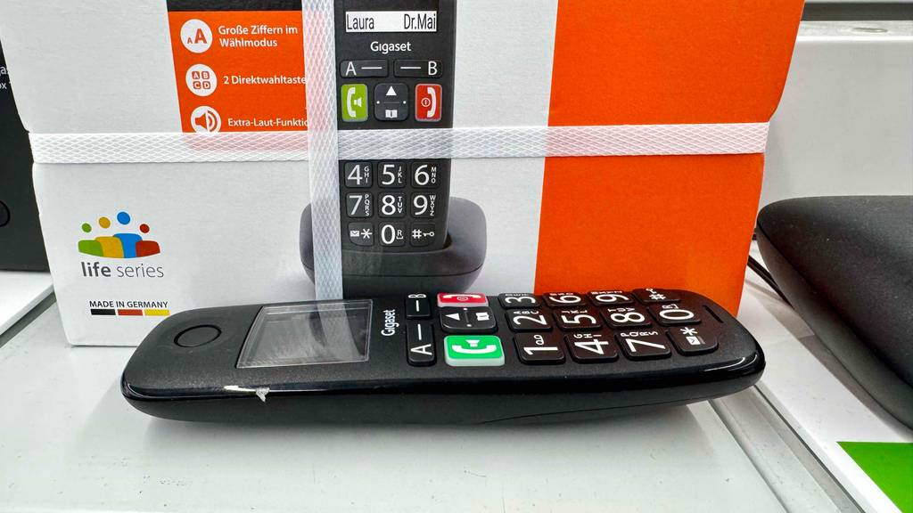 Das getestete Gigaset-Dect-Telefon liegt vor seiner Verpackung auf einem Ausstellungsregal im Verkaufsbereich.