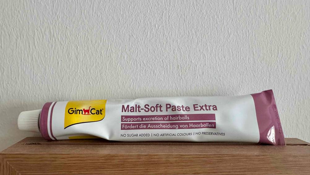 Malzpaste für Katzen-Test: Die bereits genutzte Tube ist vor einer weißen Wand platziert.
