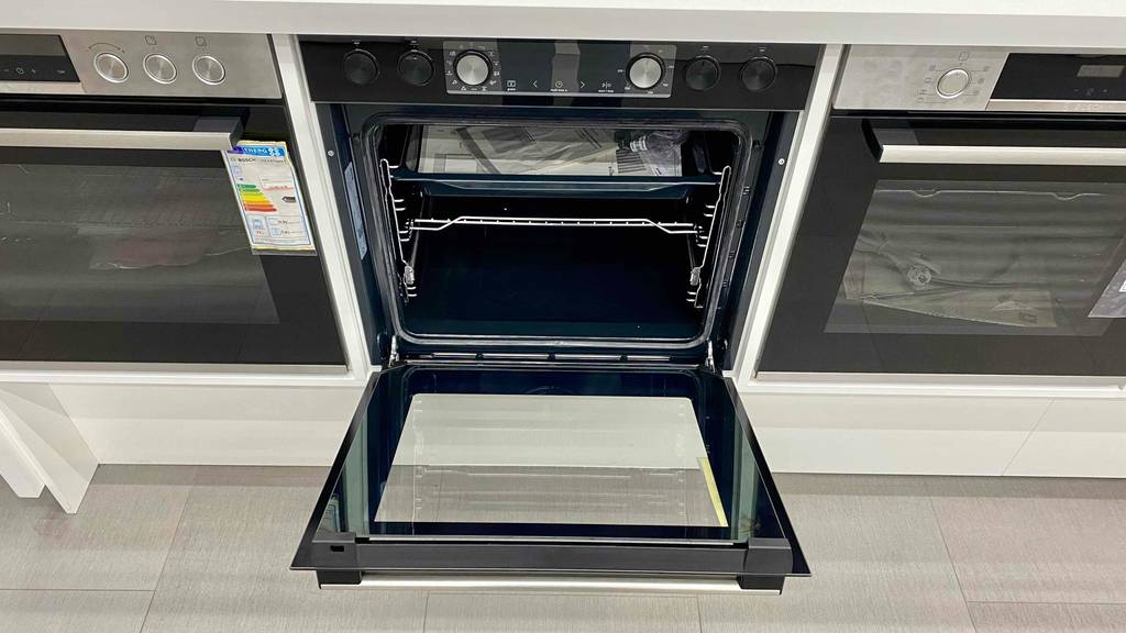 Backofen-300-Grad getestet: ein Backofen von vorn, mit geöffneter Türe, worin sich die Betriebsanleitung befindet.
