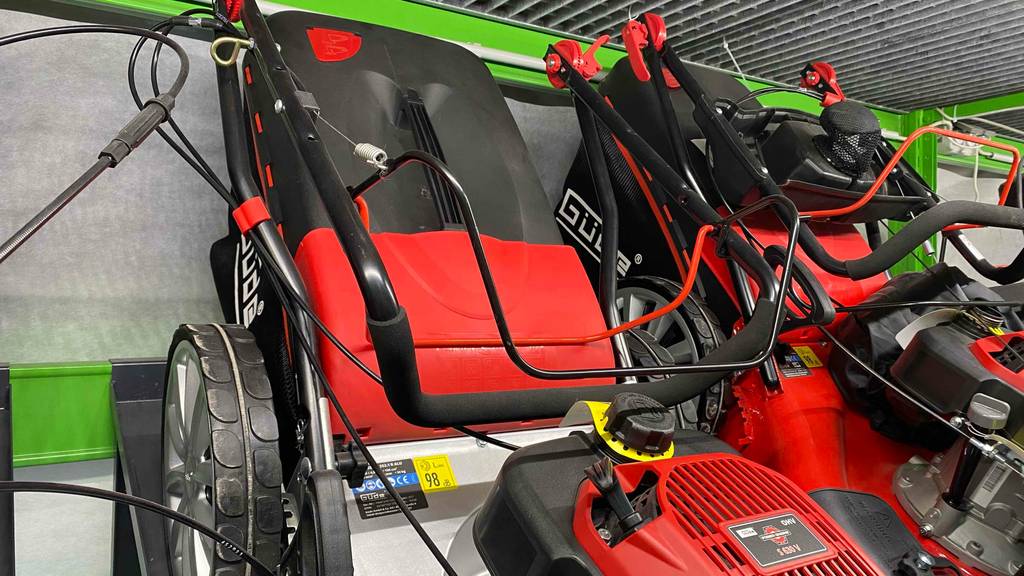 Benzin-Rasenmäher mit Mulchfunktion-Test: Ein Rasenmäher mit Blick auf das hintere Teil mit Etikett darauf, worauf 98 dB als Geräuschpegel gekennzeichnet ist.