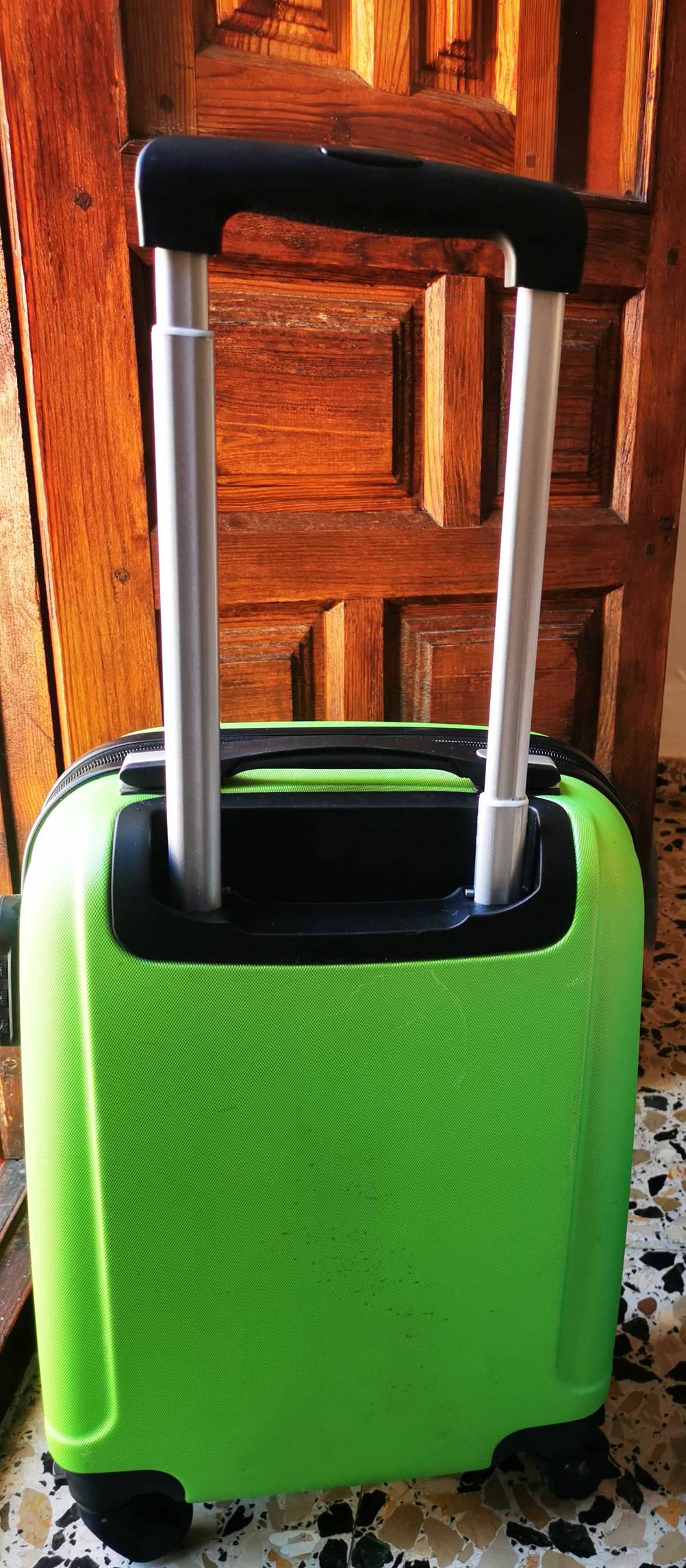 Der grüne Handgepäck-Koffer im Test steht mit ausgezogenen Handgriff auf dem Boden.