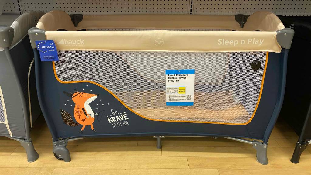Reisebett getestet: Ein Bett von der Seite auf einem Holzboden.