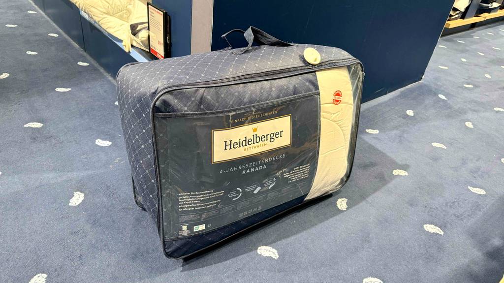 Die getestete Bettdecke-200x220 steht auf dem Boden in der Tragetasche.