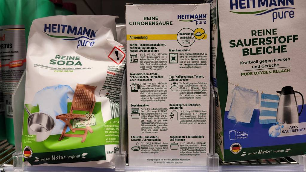 Getestete Zitronensäure in einer Verpackung, mit Fokus auf die Anwendungsbeschreibung, steht in einem Verkaufsregal neben anderen Reinigungsmitteln.