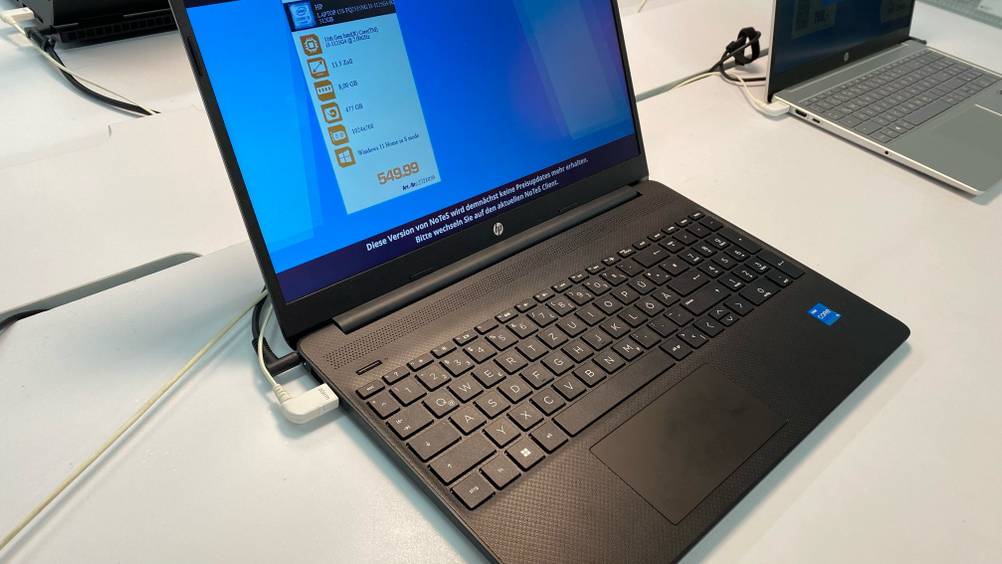 HP-Laptop getestet: Ein angeschaltetes geöffnetes Gerät neben einem anderen auf einer weißen Fläche.