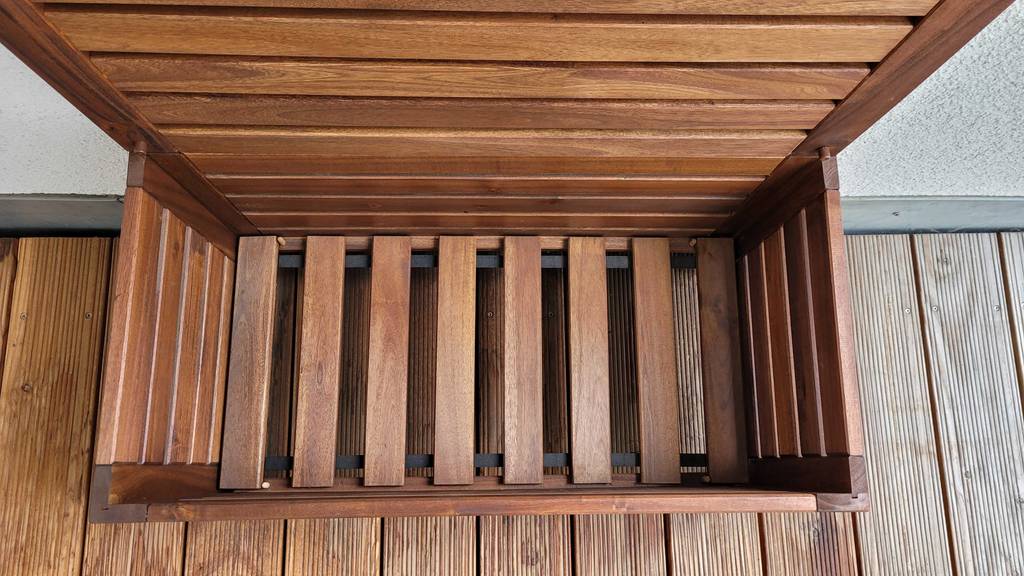 Gartenbank aus Holz mit geöffnetem Stauraum