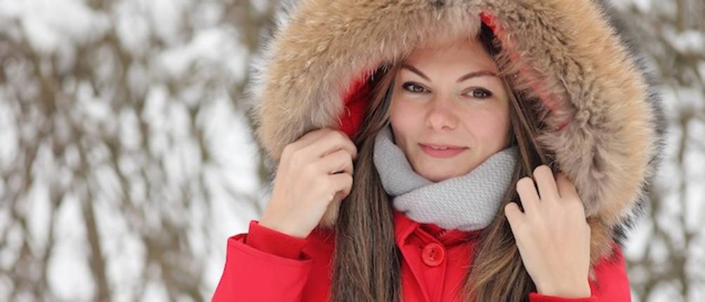 3-in-1-Damen-Jacken-Test: Eine Frau mit einer roten Winterjacke mit Kapuze mit Fellbesatz in Nahaufnahme.