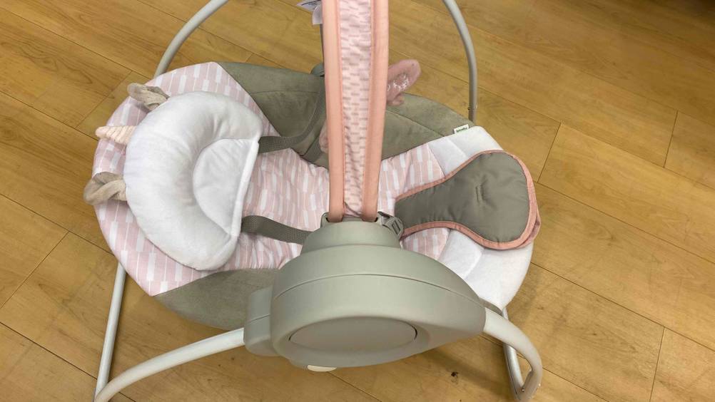 Babyschaukel getestet: Eine Schaukel seitlich von oben auf einem Holzboden stehend