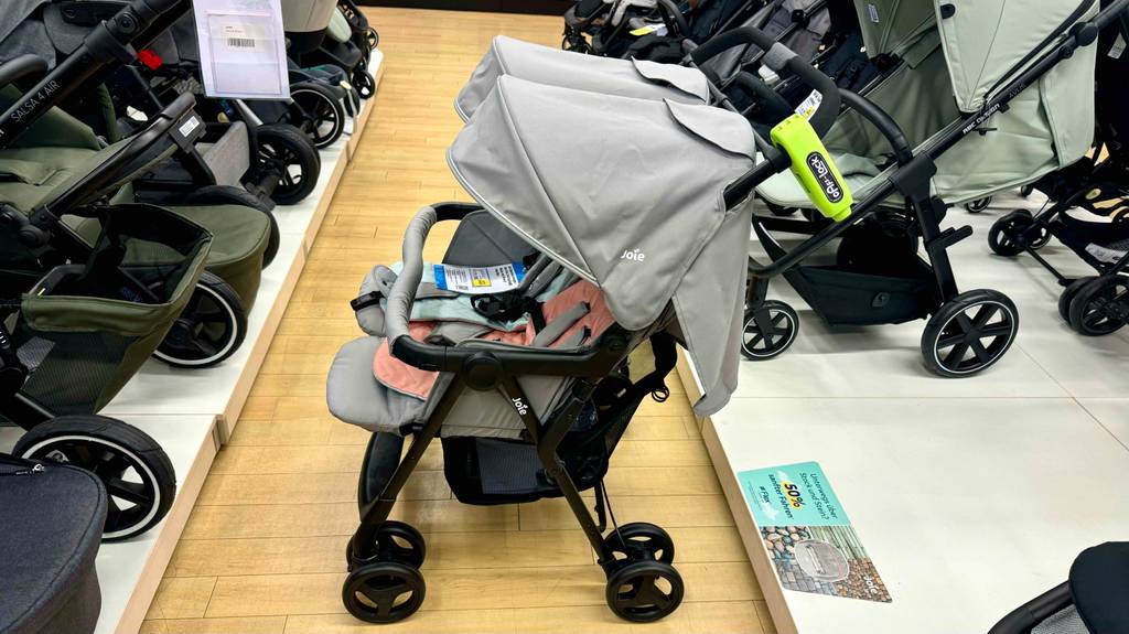 Der getestete Zwillingskinderwagen ist in einem Geschäft ausgestellt, welcher von der Seite ersichtlich ist.