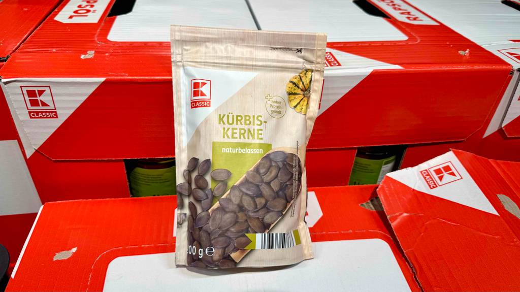 Eine Packung getestete Kürbiskerne, welche naturbelassen sind, befinden sich auf befüllte Kartons.