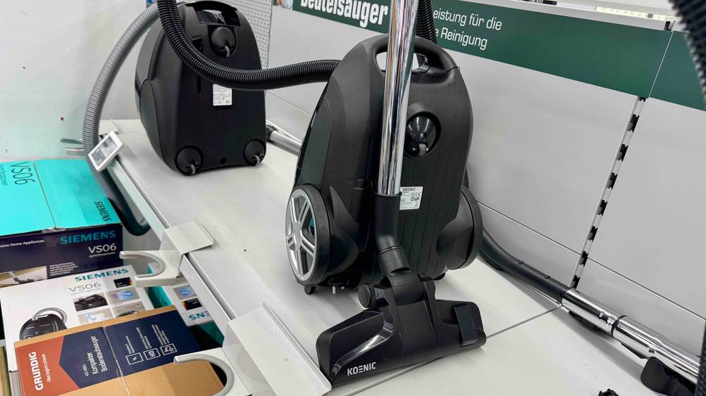 Der getestete Staubsauger unter 100 Euro steht in einem Regal neben anderen Modellen.