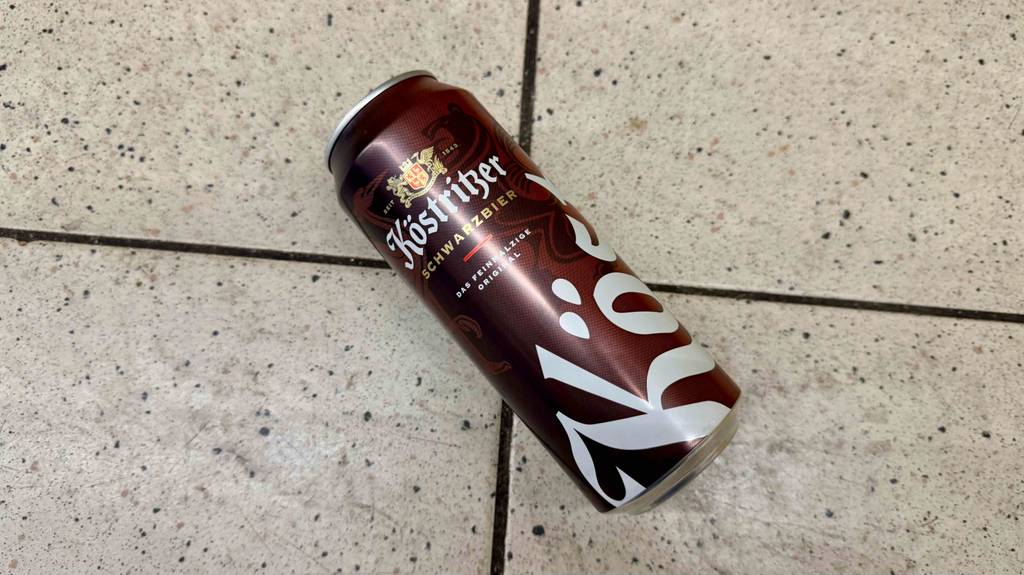 Eine Dose getestetes Schwarzbier liegt auf einem Fliesenboden.