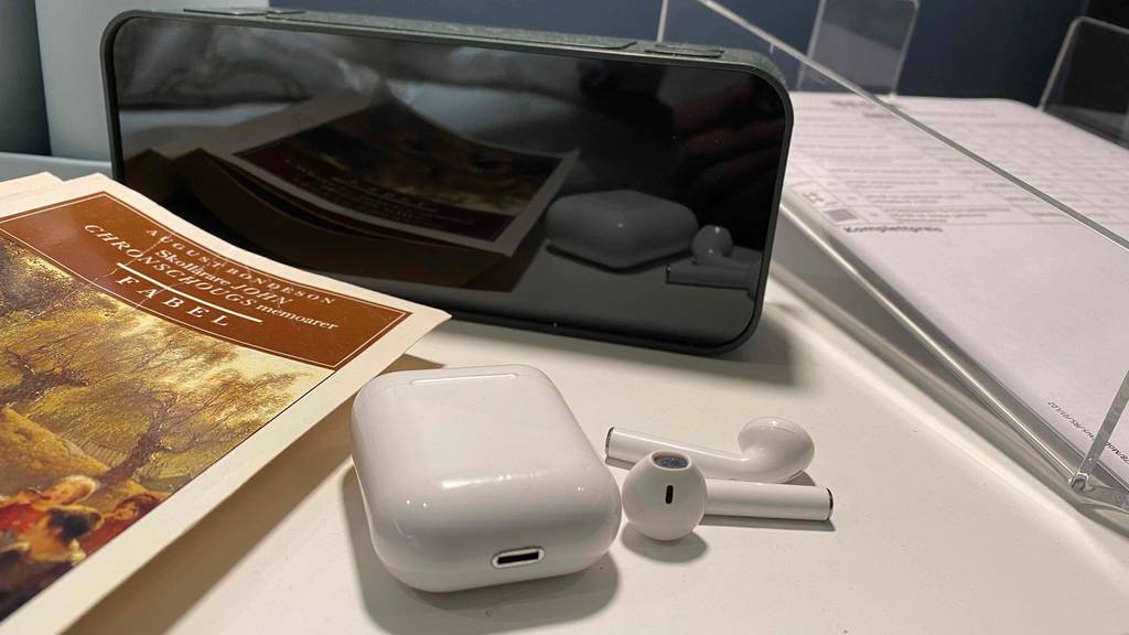 Kopfhörerbox, Kopfhörer und Handy zu sehen.