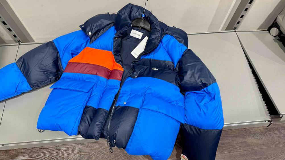 Die getestete Winterjacke liegt samt dem Kleiderbügel auf einem Regalboden.