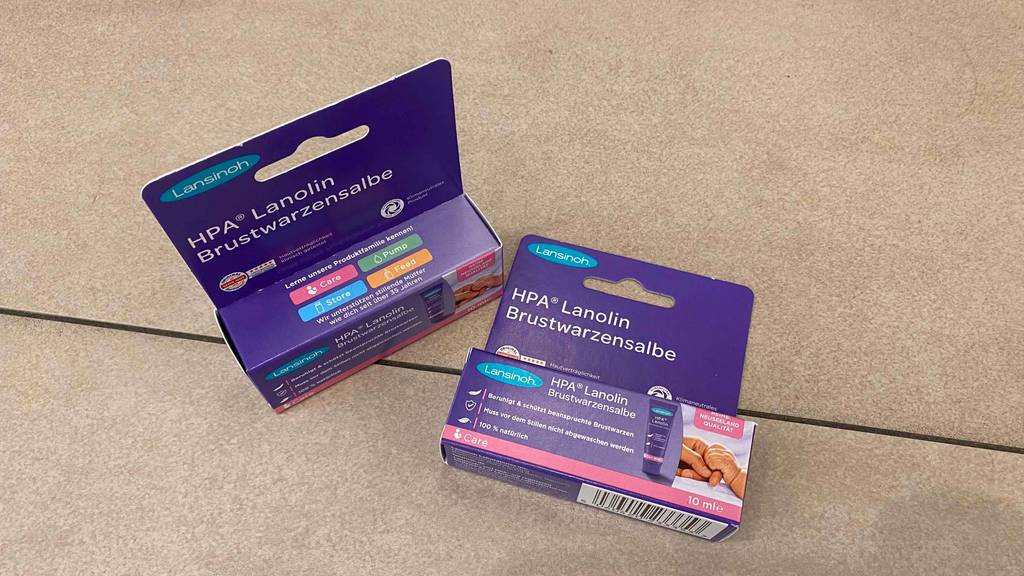 Brustwarzensalbe getestet: zwei verschlossene Verpackungen von Brustwarzensalbe der Marke Lansinoh - eine Verpackung liegend und die andere stehend.