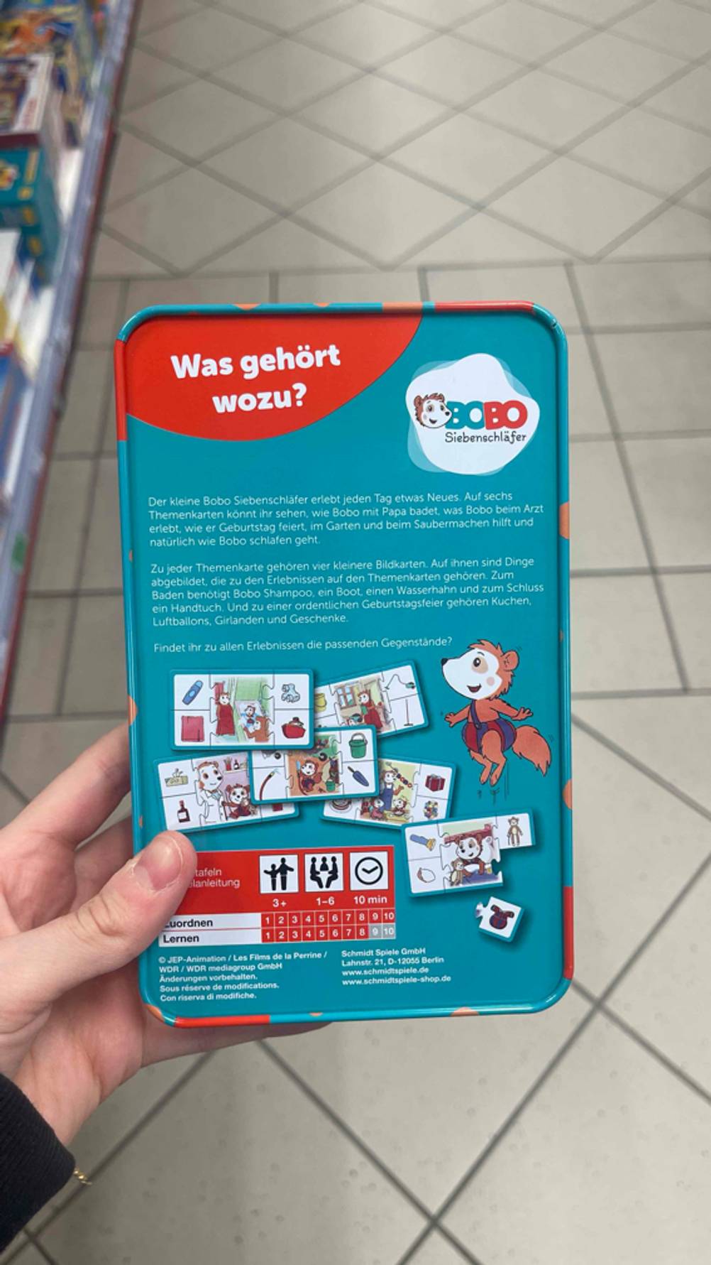 Rückseite des getesteten Lernspiels, das in der Hand gehalten wird.