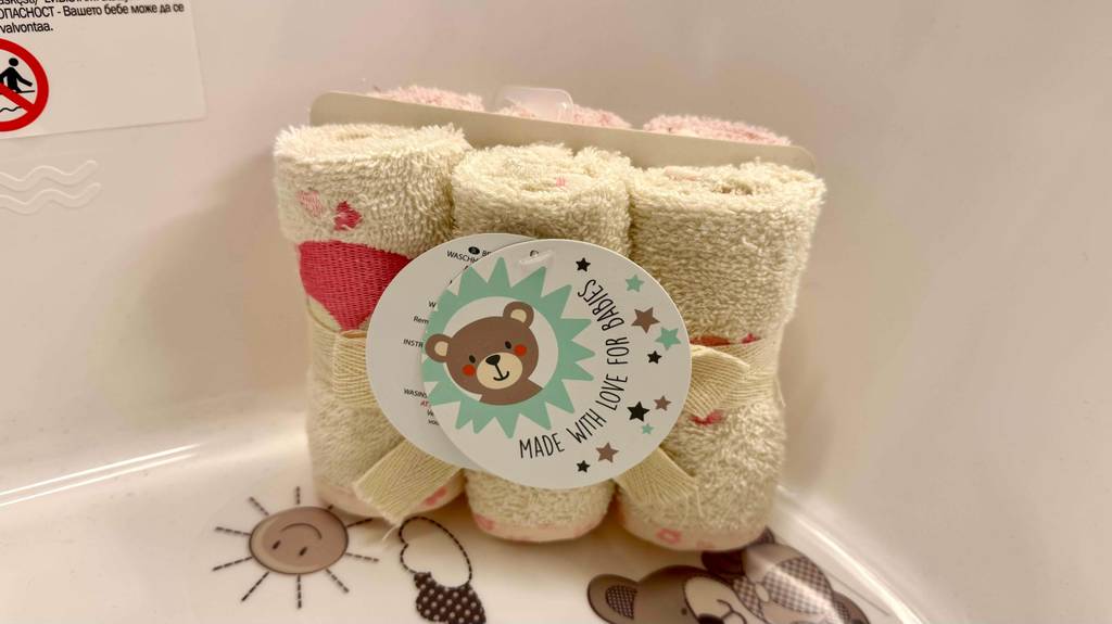 Mehrere getestete Waschlappen für Babys sind in einem Set zusammengebunden mit einem kindergerechten Etikett darauf.