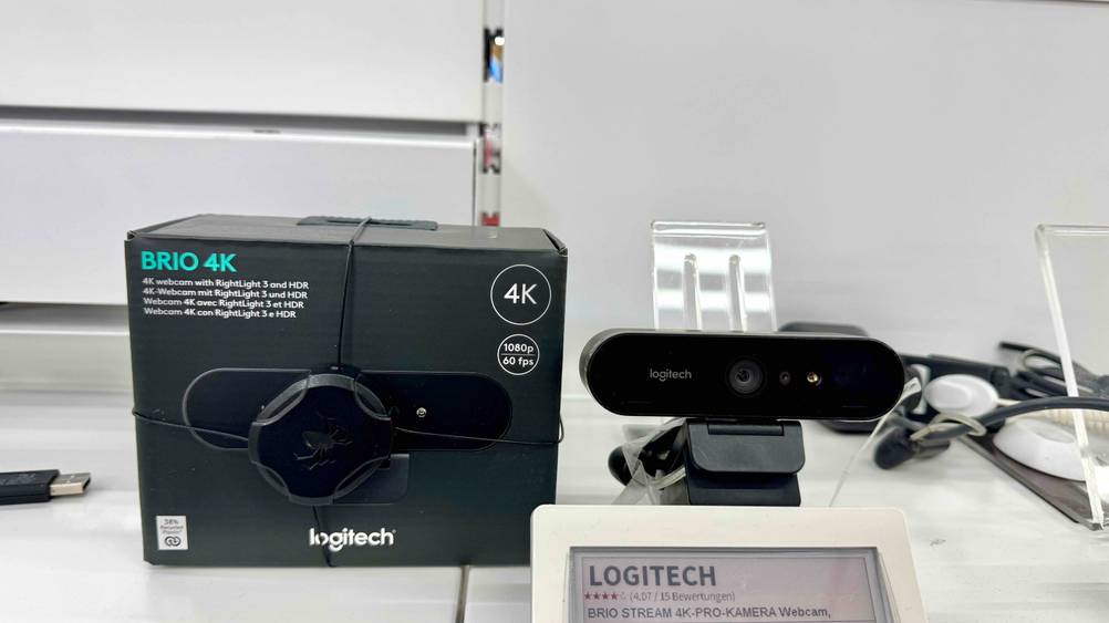 Die ausgepackte 4K-Webcam, die getestet wurde steht neben der Verpackung.
