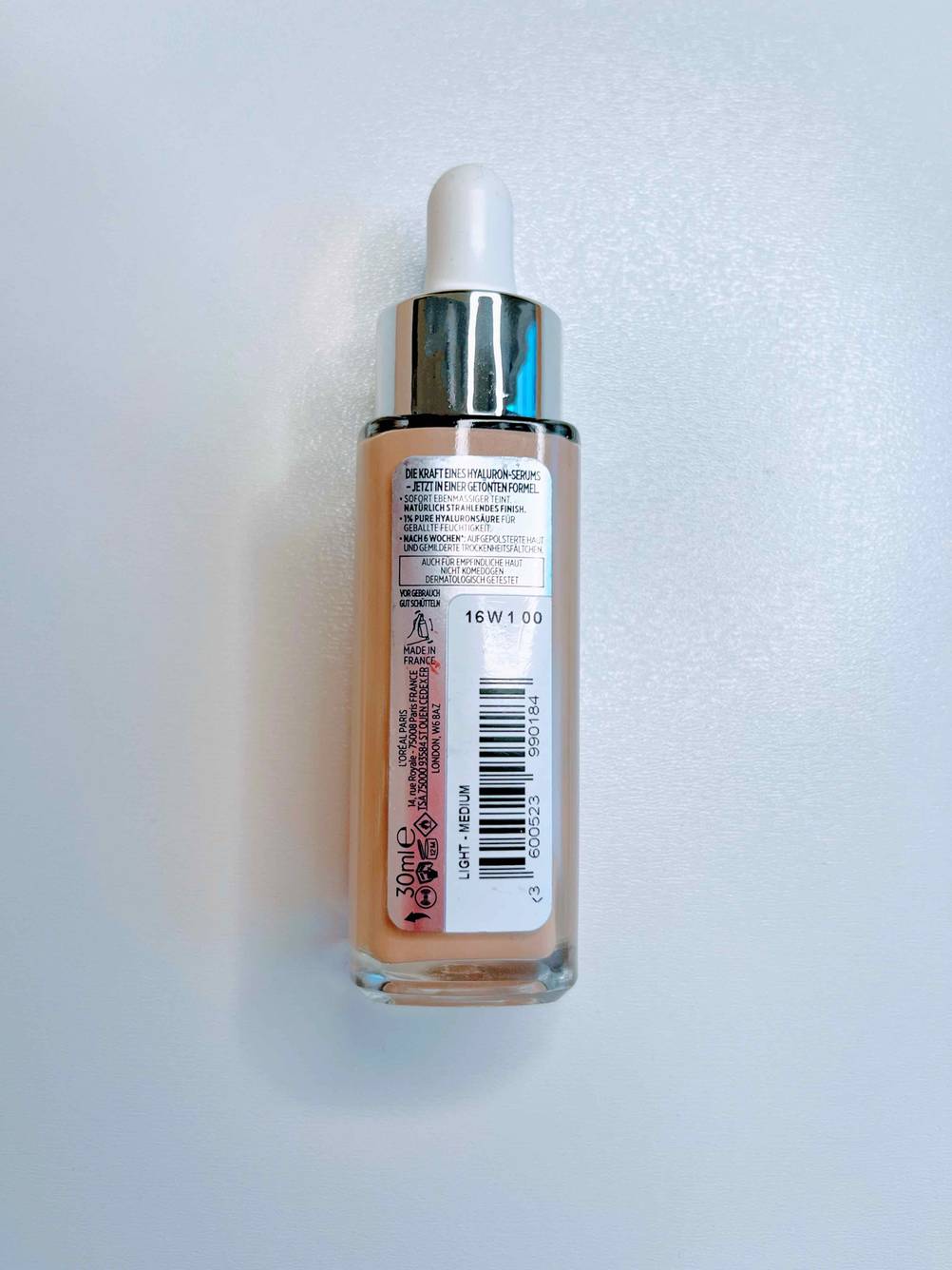 Eine Flasche des getesteten Make-ups liegt mit der Rückseite nach oben auf einer hellen Fläche.