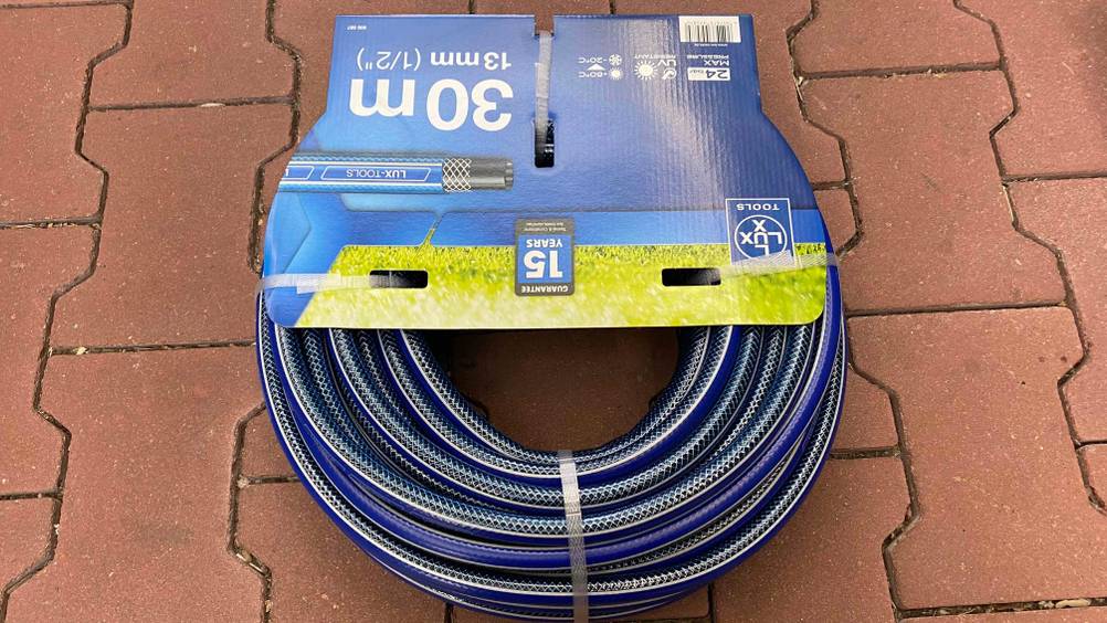 Gartenschlauch im Test: Ein Schlauch originalverpackt auf einem Steinboden