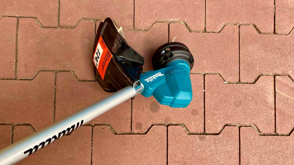 Unterer Teil eines getesteten Makita-Rasentrimmer, welcher am Boden platziert ist, worauf man das Preisschild sieht.