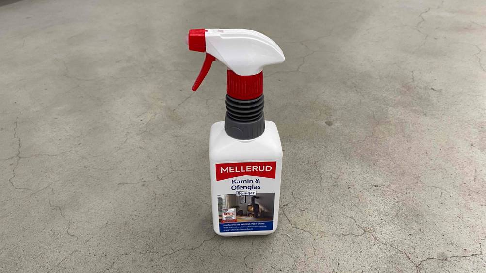 Ein Mellerud-Kaminreiniger im Test steht in einer Sprühflasche auf grauem Untergrund.