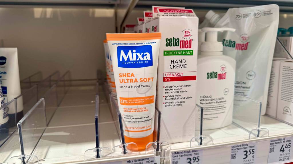 Getestete Mixa-Handcreme steht in einem Regal neben anderen Produkten.