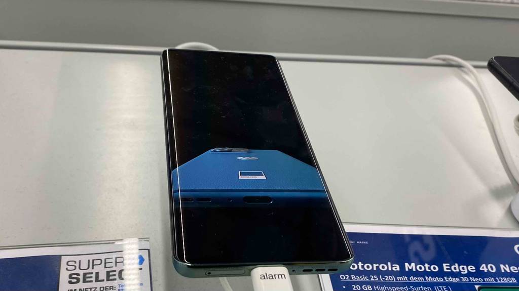Ein getestetes Motorola-Smartphone in einer Halterung auf einer hellen Fläche.