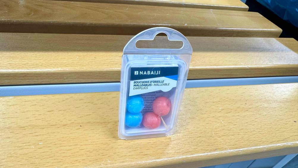 Die transparente Verpackung der getesteten Silikon-Ohrstöpsel, ist auf einer Sitzbank platziert, worin sich die Ohrstöpsel befinden.