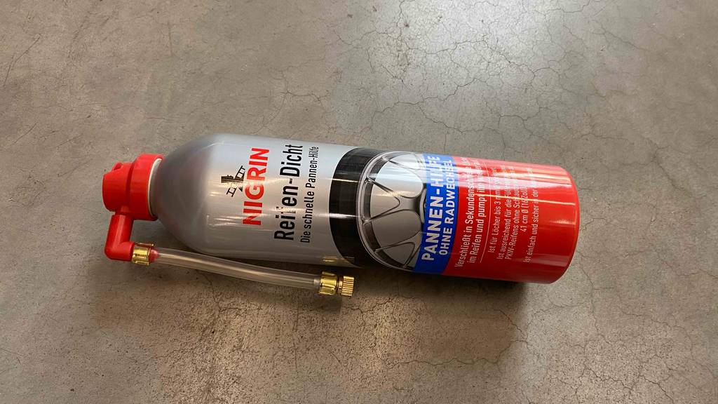 Reifendichtmittel-Test: eine Flasche Reifendichtmittel liegt horizontal auf einem Boden.