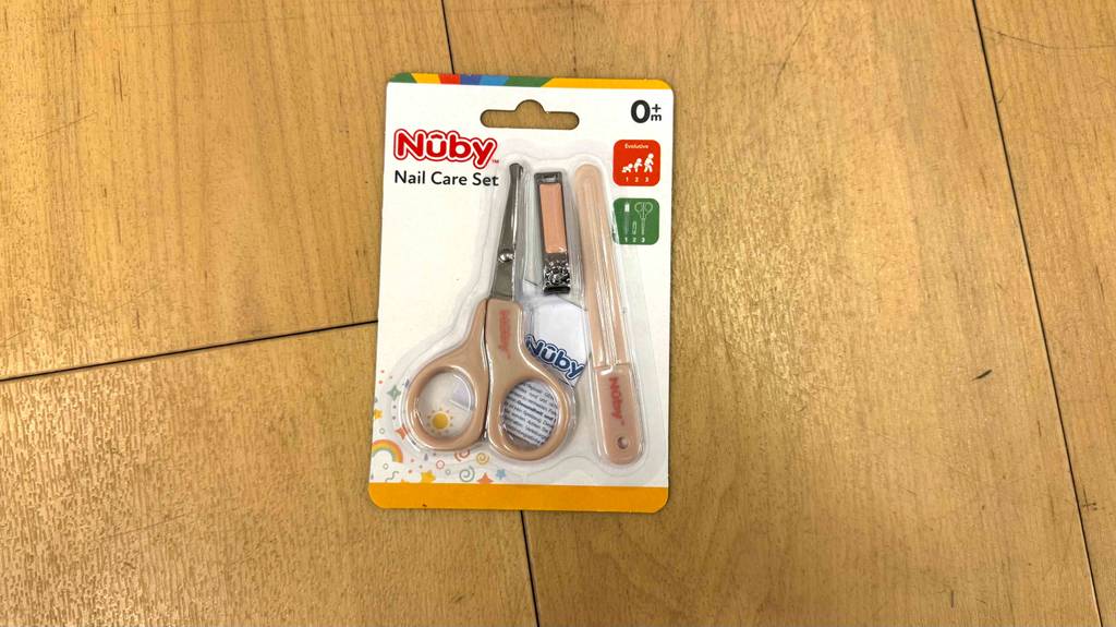 Ein getestetes Baby-Nagelset befindet sich in der Verpackung und ist auf einer Holzfläche platziert.