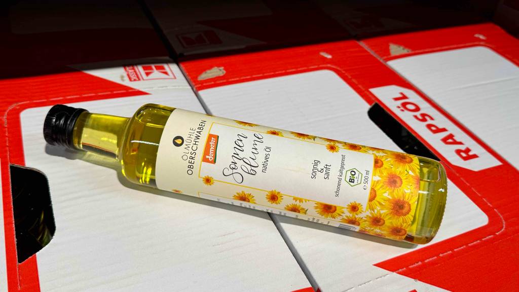 Test: Eine Flasche Sonnenblumenöl liegt auf Kartons.