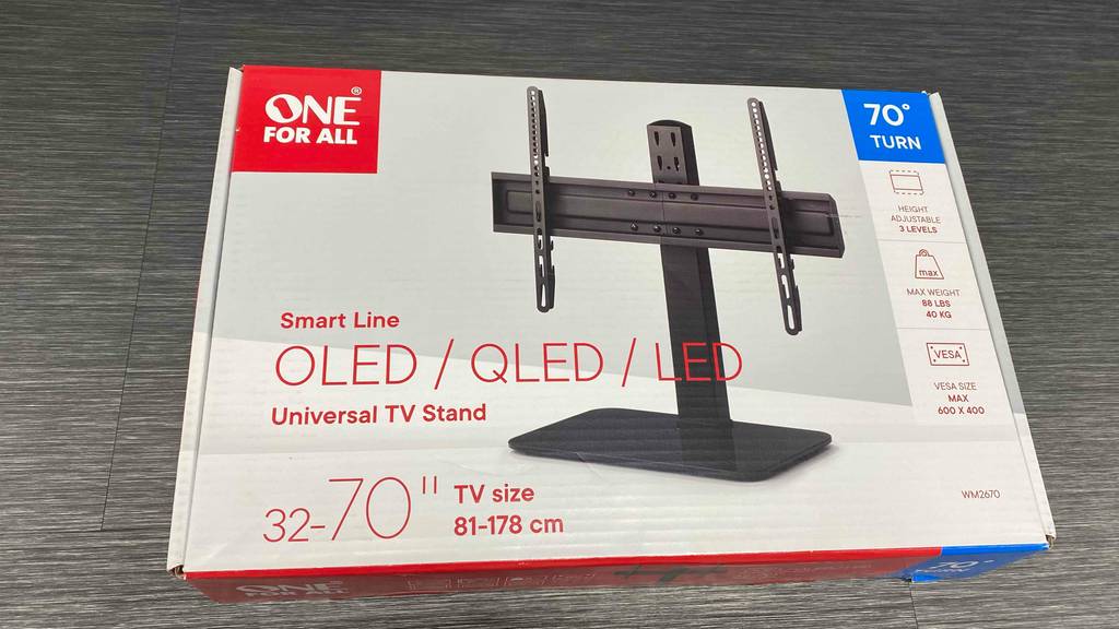 Ein getesteter TV-Ständer in Originalverpackung auf einer Holzfläche.