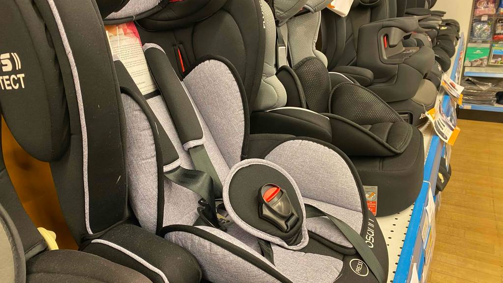 Kindersitz 9–36 kg getestet: Ein Sitz von der Seite zwischen anderen im Regal.