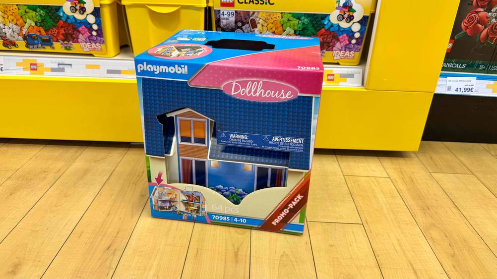 Das getestete Playmobil-Haus steht vor einem Regal, worin sich Lego befindet.