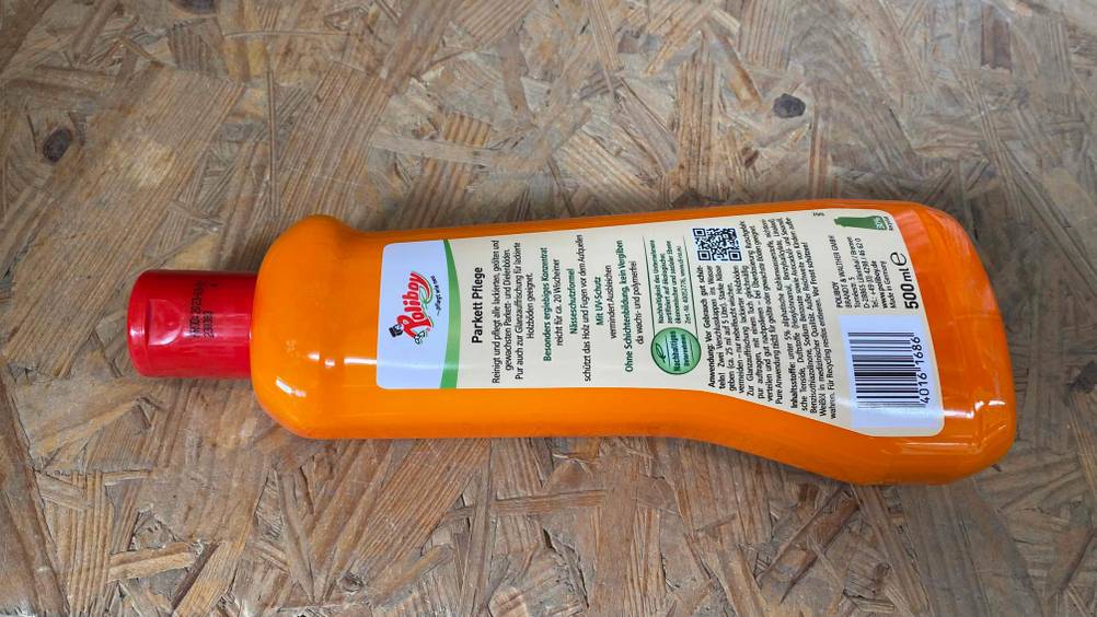 Parkett Konzentrat getestet: Auf eine Holzfläche liegt eine Flasche Parkett Konzentrat mit der Rückseite nach oben