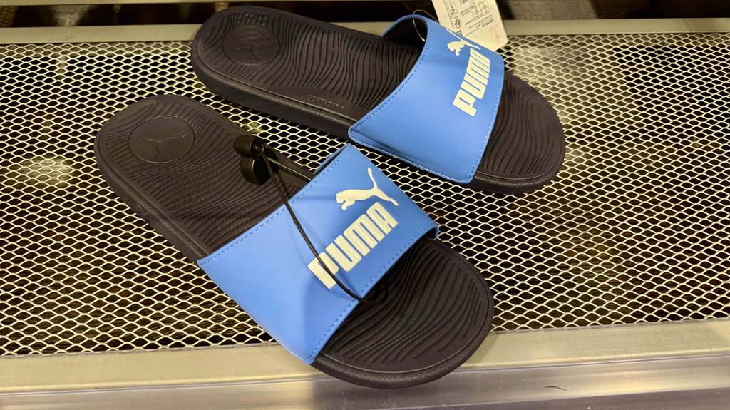 Test: Ein Paar Badeschuhe von Puma stehen auf einem Gitter.