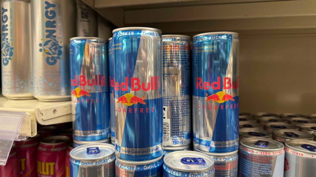 Mehrere Dosen getesteter Red-Bull-Energy-Drinks stehen übereinander in einem Regal.