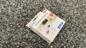 Schrank-Kindersicherung getestet: Eine Packung liegt auf einem grauen Teppich.