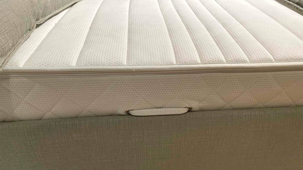 Taschenfederkernmatratze-140x200-Test: eine Taschenfederkernmatratze von der Seite auf einem Bett ersichtlich.