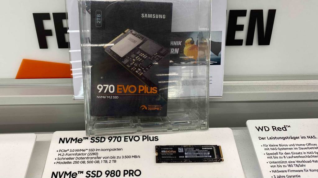 Die Packung einer getesteten M.2-SSD mit 2 TB ist vor der ausgestellten SSD ausgestellt.