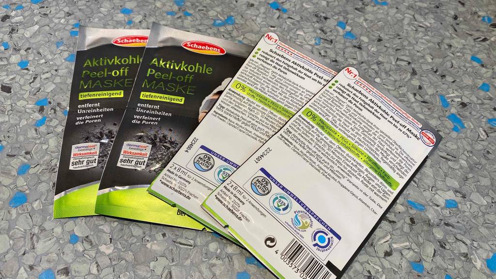 Aktivkohle-Maske getestet: Mehrere Packungen nebeneinander einige zeigen Rückseite