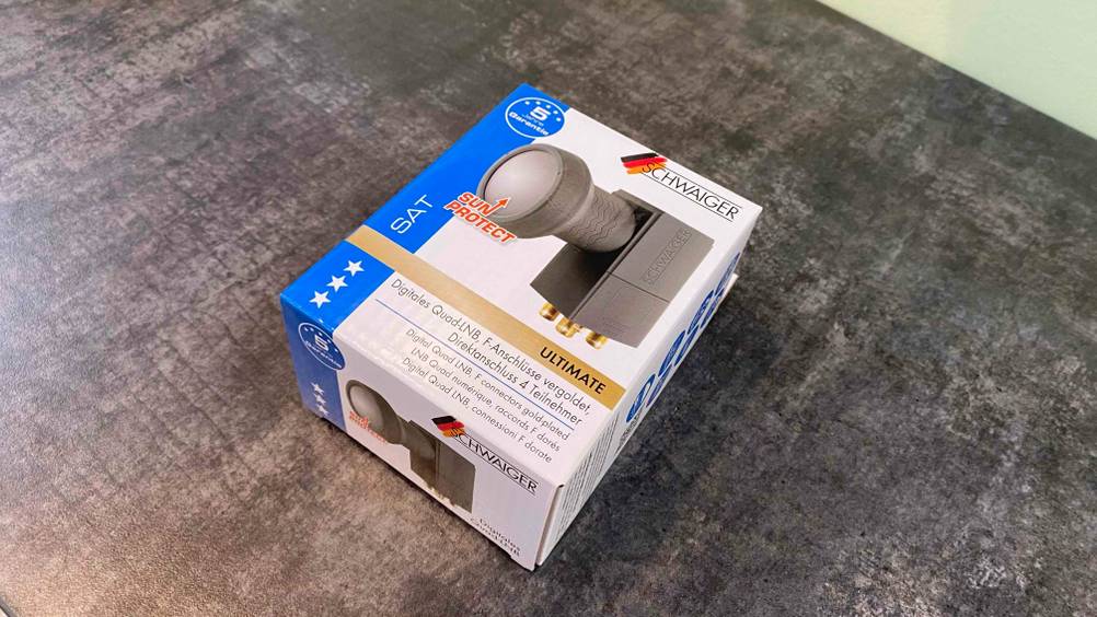 Auf einer dunklen Oberfläche liegt ein getestetes LNB in seiner Verpackung.
