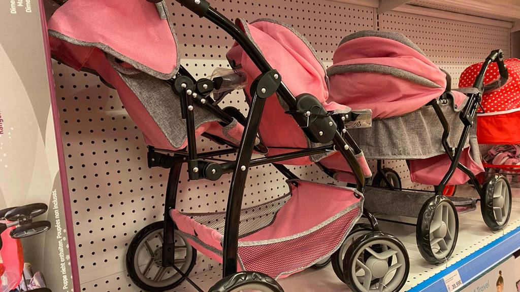 Zwillingspuppenwagen getestet: Ein Wagen von schräg hinten neben anderen Produkten im Regal stehend.